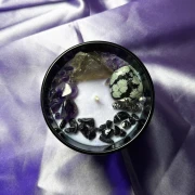 Widok z góry na ezoteryczną świecę rytualną Hekate, ukazujący bogatą kompozycję naturalnych minerałów ochronnych, w tym surowy obsydian i kwarc dymny.