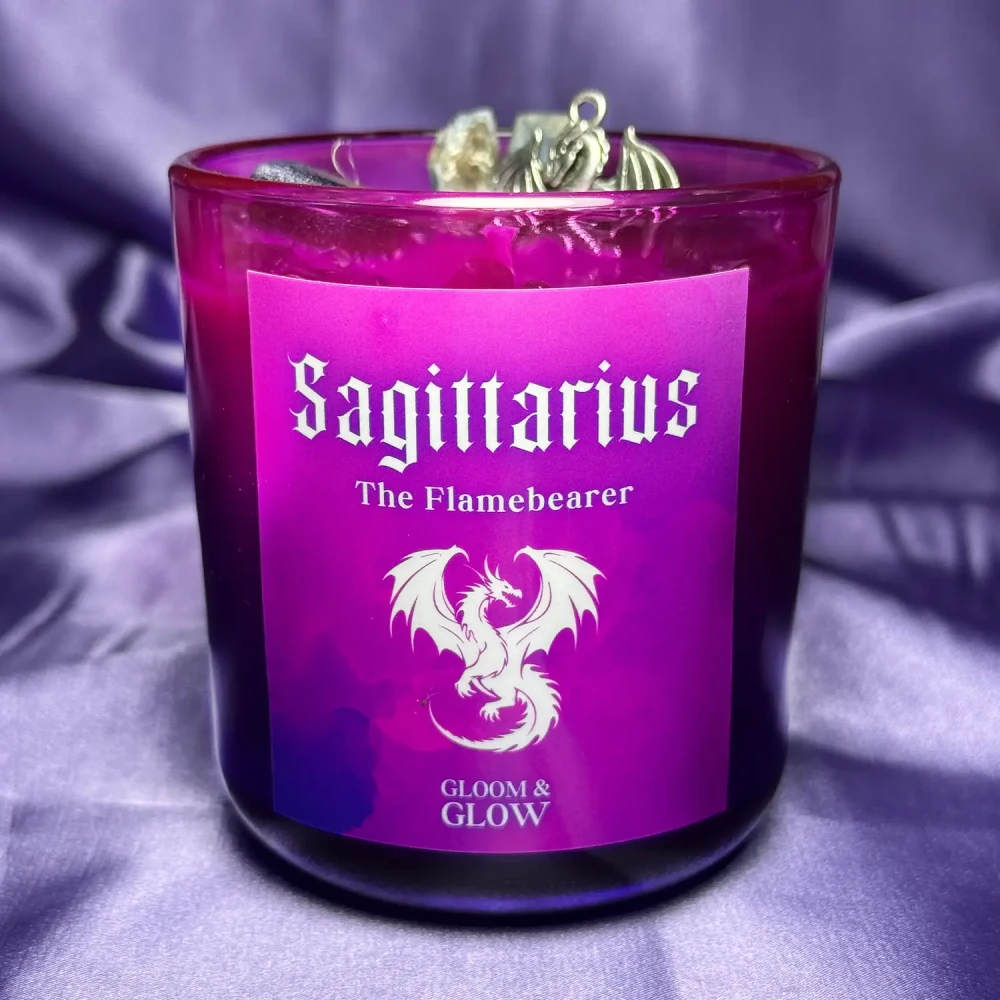 Fioletowa ezoteryczna świeca sojowa Sagittarius marki Gloomandglow z etykietą przedstawiającą smoka na satynowym tle.
