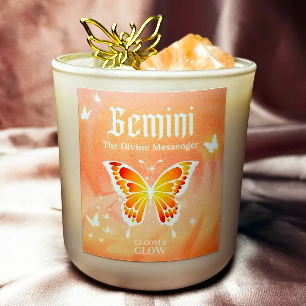 Jasna ezoteryczna świeca sojowa Gemini marki Gloomandglow z etykietą przedstawiającą motyla na satynowym tle.