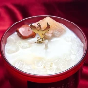 Zbliżenie na wosk i minerały ze złotym feniksem w świecy sojowej Aries, ezoteryka i zodiak od Gloomandglow.