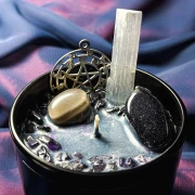 Zbliżenie na mieniący się wosk, minerały i amulety w ezoterycznej świecy bogini nocy Nyx, kategoria ezoteryka Gloomandglow.