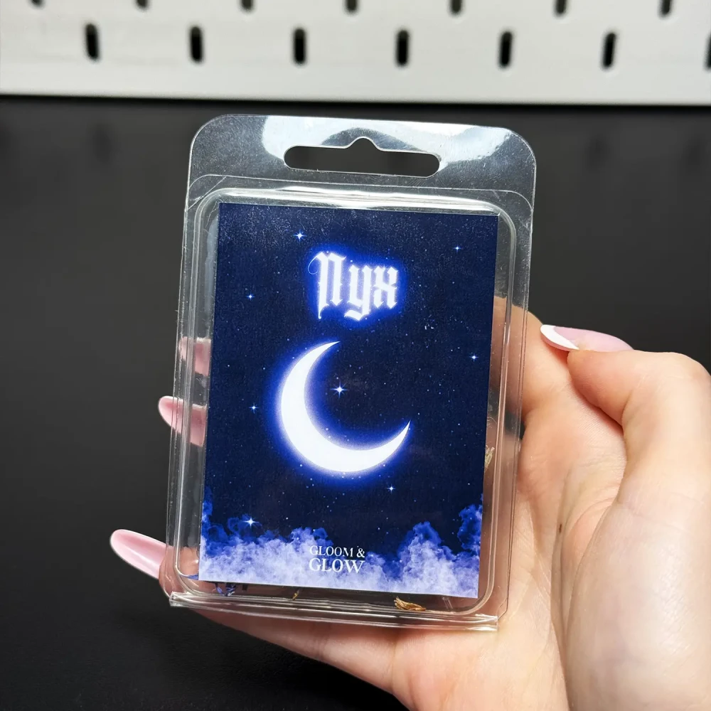 Wosk sojowy do kominka Nyx z etykietą przedstawiającą świecący półksiężyc i nocne niebo, ezoteryka i woski zapachowe Gloomandglow.